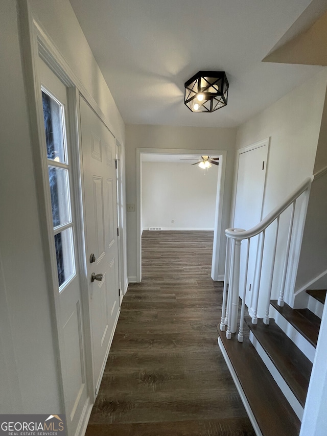 hallway with stairway, baseboards, and dark wood-style flooring