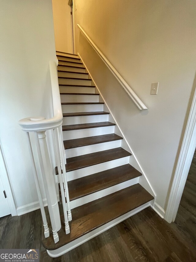 staircase with baseboards and wood finished floors