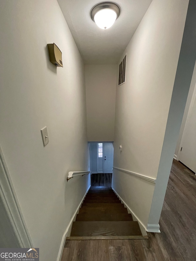 stairs with visible vents, baseboards, and wood finished floors