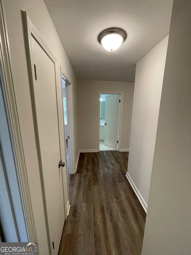 hall with baseboards and dark wood-style floors