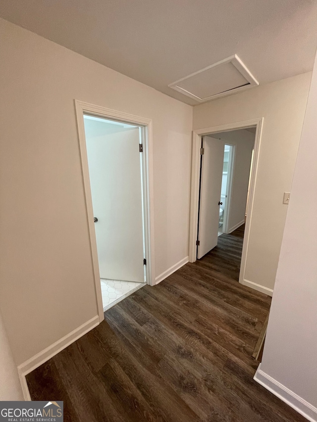 hallway with attic access, wood finished floors, and baseboards