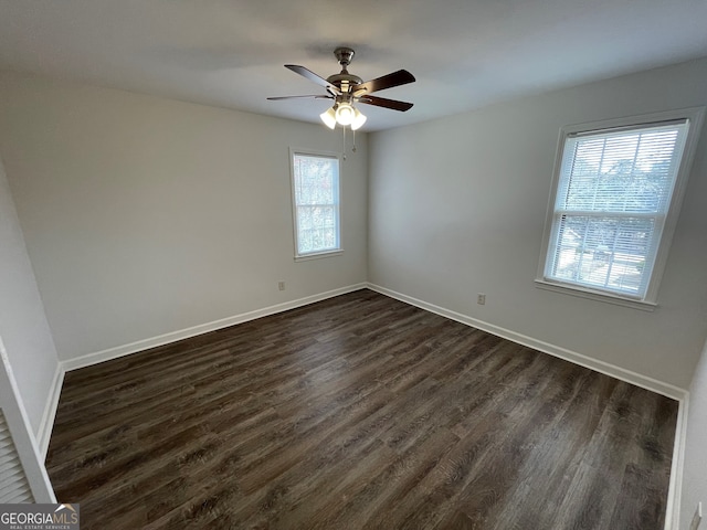 spare room with dark wood-style floors, baseboards, and ceiling fan