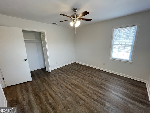 unfurnished bedroom with visible vents, baseboards, dark wood finished floors, a closet, and a ceiling fan