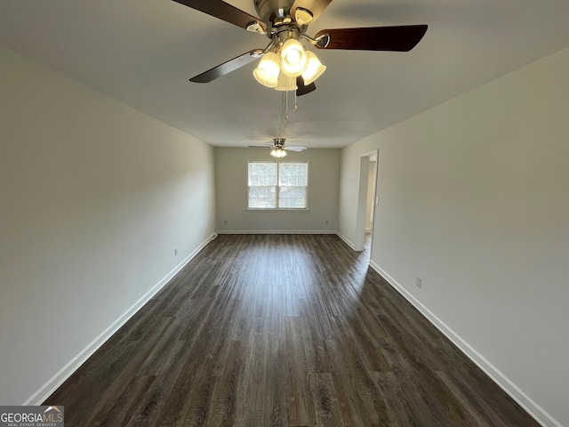 unfurnished room with baseboards and dark wood-style flooring