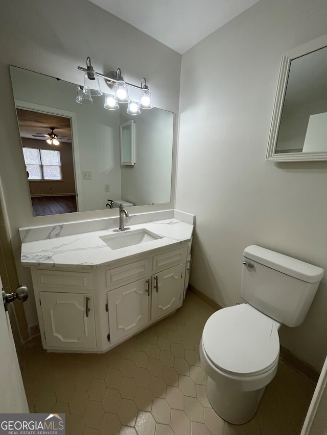 half bath featuring vanity, toilet, and baseboards