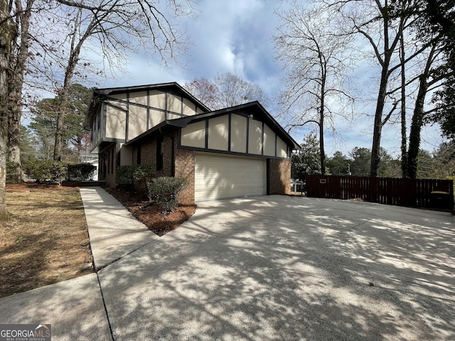 view of property exterior with brick siding, fence, stucco siding, driveway, and an attached garage