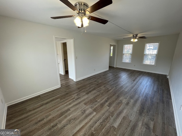 spare room with baseboards and dark wood-style flooring