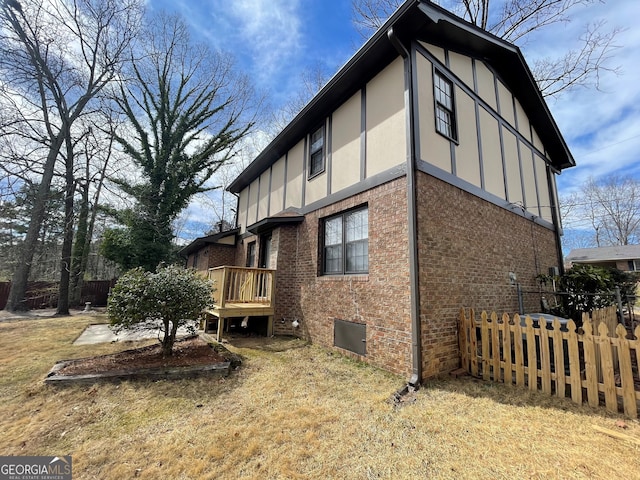 view of side of property with brick siding, stucco siding, and fence