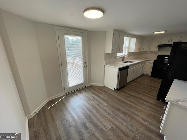 kitchen with under cabinet range hood, a sink, stainless steel dishwasher, black / electric stove, and light countertops