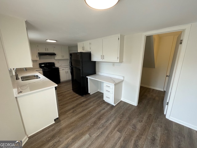 kitchen featuring under cabinet range hood, dark wood-style flooring, black appliances, and a sink