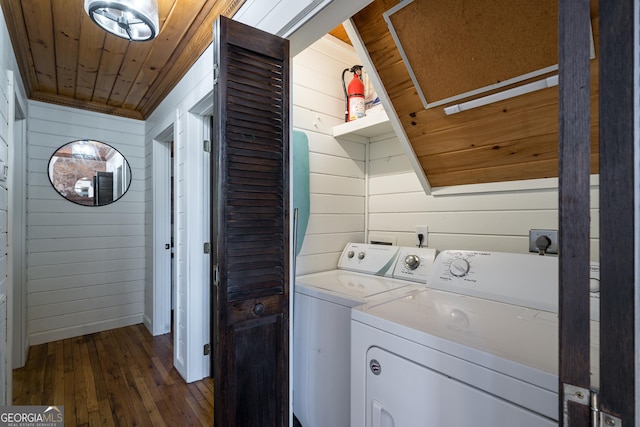 laundry room with washing machine and clothes dryer, laundry area, dark wood-type flooring, wood walls, and wooden ceiling