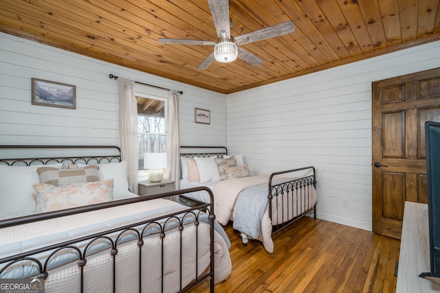 bedroom featuring hardwood / wood-style floors, wood ceiling, and ceiling fan