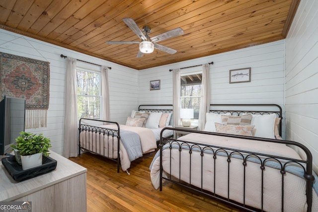 bedroom featuring ornamental molding, a ceiling fan, wood finished floors, wooden ceiling, and a sunroom