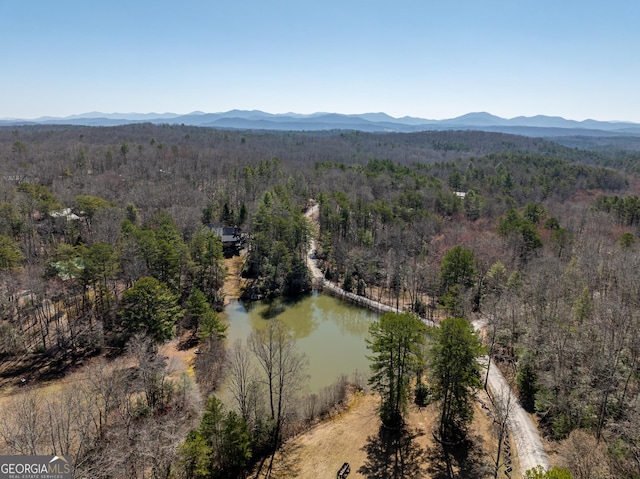 aerial view featuring a wooded view and a water and mountain view