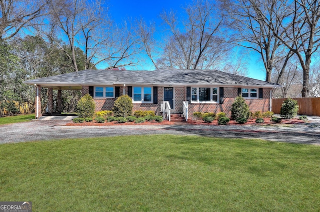 ranch-style home with a front lawn, driveway, a carport, fence, and brick siding