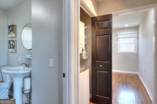 bathroom featuring washer / dryer, wood finished floors, and baseboards