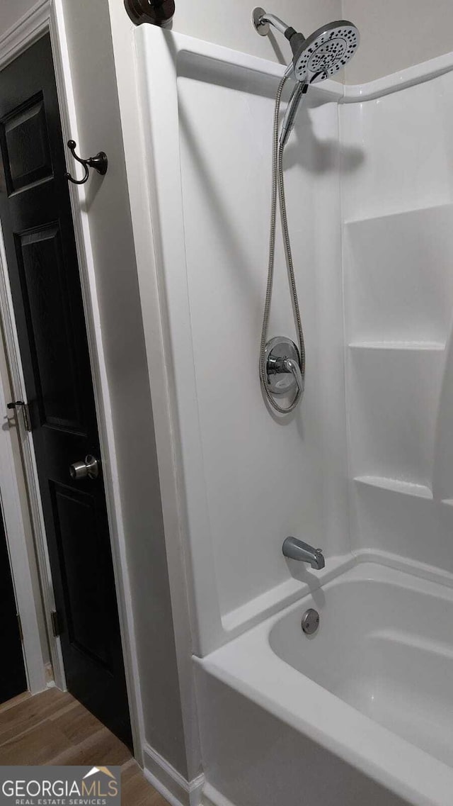 bathroom featuring bathing tub / shower combination and wood finished floors