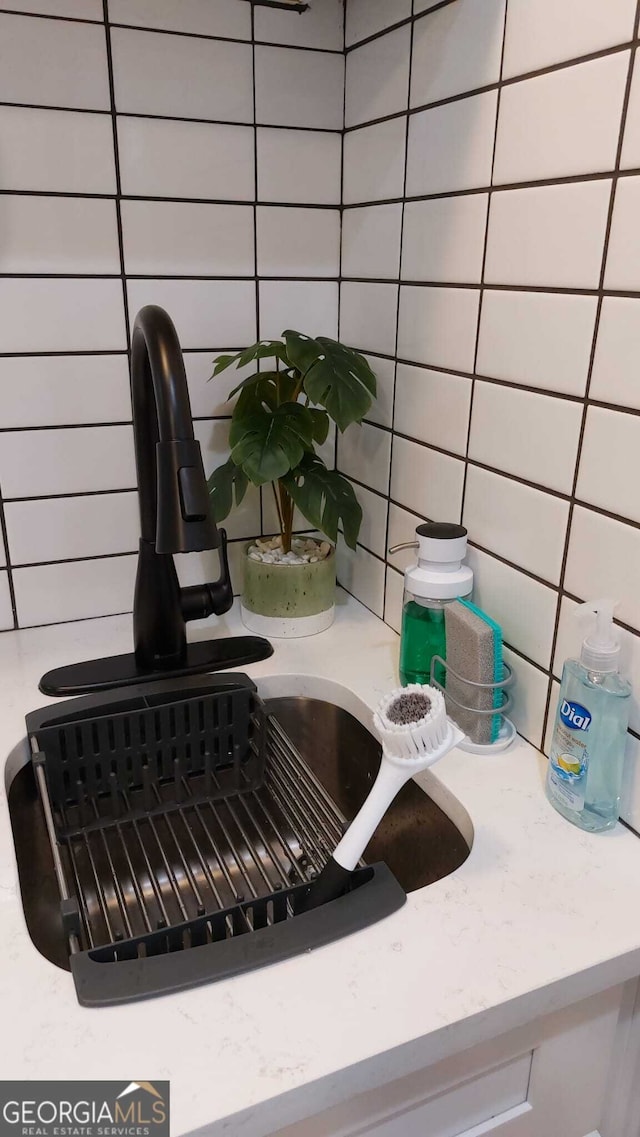 room details featuring backsplash and a sink