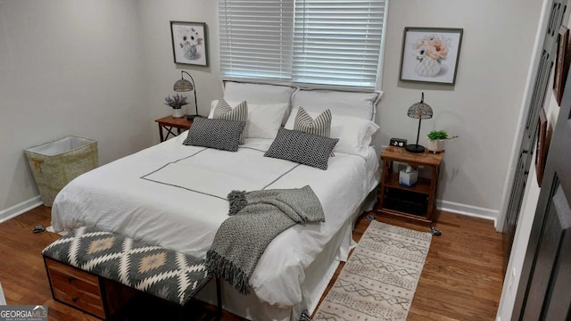 bedroom with baseboards and wood finished floors