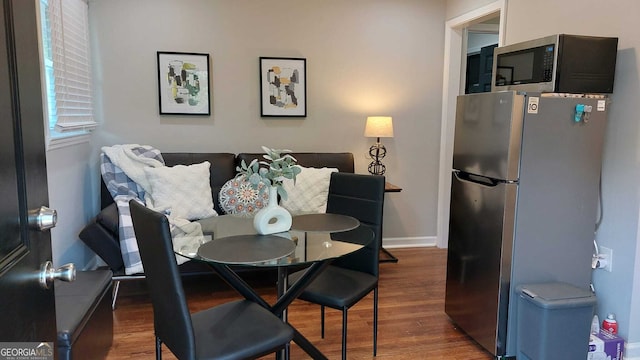 dining space featuring baseboards and wood finished floors