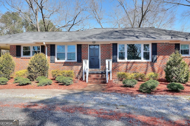 ranch-style house with brick siding and a shingled roof