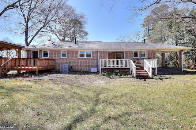 rear view of property featuring crawl space, a yard, brick siding, and a wooden deck