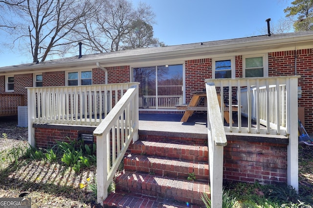 exterior space featuring brick siding and a deck