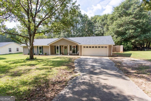 ranch-style house with fence, driveway, a porch, a front lawn, and a garage