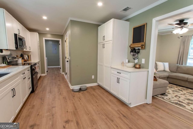 kitchen featuring white cabinetry, light wood-style floors, visible vents, and stainless steel appliances