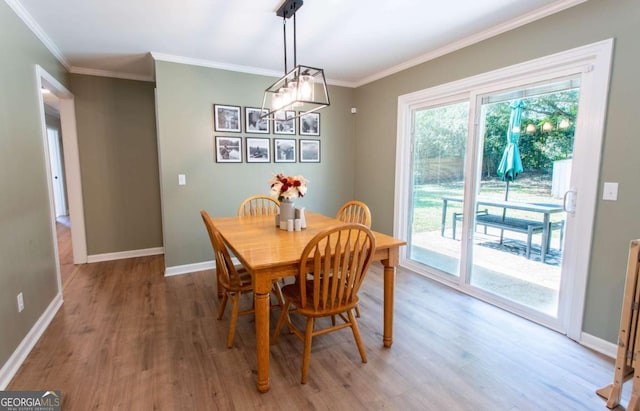 dining space with light wood-type flooring, baseboards, and crown molding