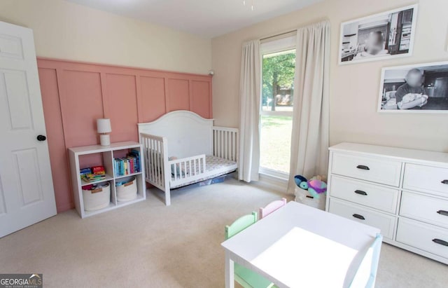 bedroom featuring light carpet and a crib