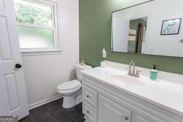 bathroom featuring tile patterned flooring, toilet, vanity, and baseboards