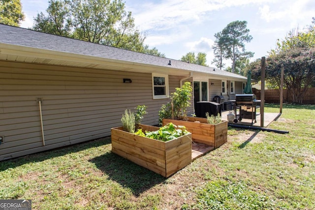 back of house with a patio, a garden, a yard, and fence