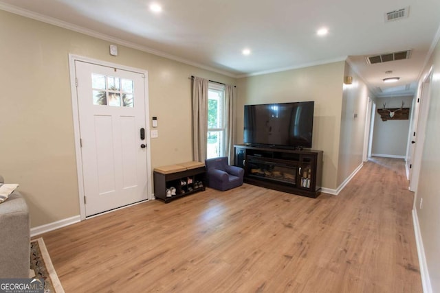 foyer featuring crown molding, baseboards, visible vents, and light wood finished floors