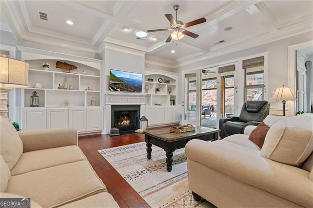 living area with visible vents, dark wood-type flooring, coffered ceiling, and a lit fireplace