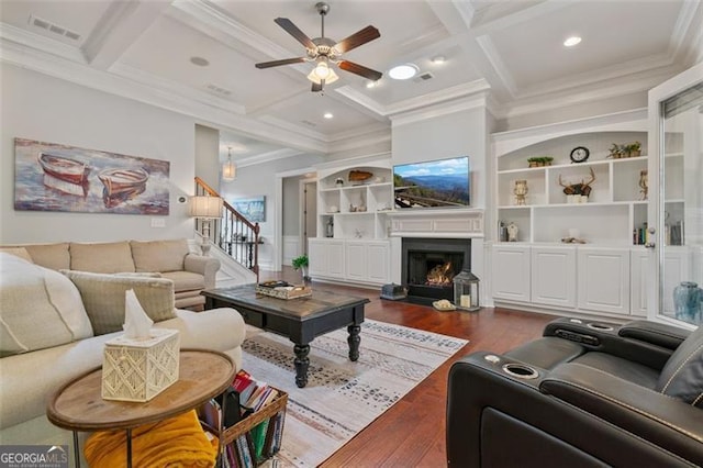 living room with beamed ceiling, dark wood-type flooring, coffered ceiling, and stairs