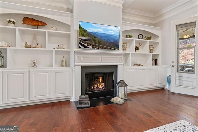 living area with dark wood finished floors, a fireplace with flush hearth, crown molding, and built in features