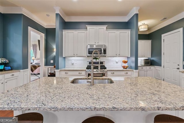 kitchen with a kitchen bar, appliances with stainless steel finishes, and white cabinets