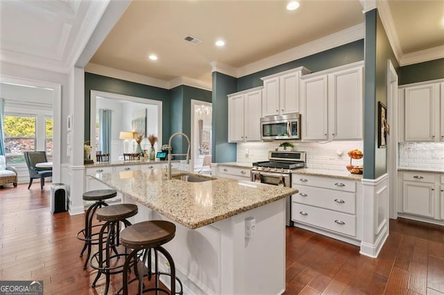 kitchen featuring visible vents, dark wood-type flooring, a sink, white cabinetry, and stainless steel appliances