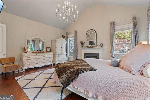 bedroom with a chandelier, a fireplace, high vaulted ceiling, and wood finished floors