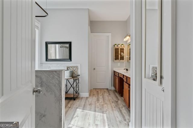 full bathroom featuring baseboards, wood finished floors, and vanity