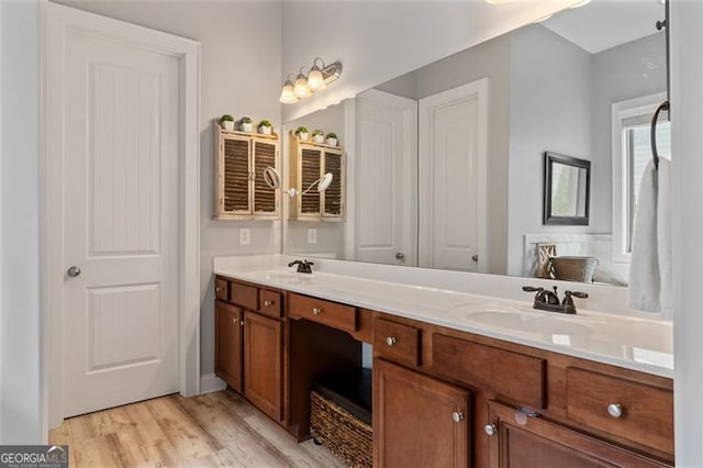 bathroom with double vanity, wood finished floors, and a sink