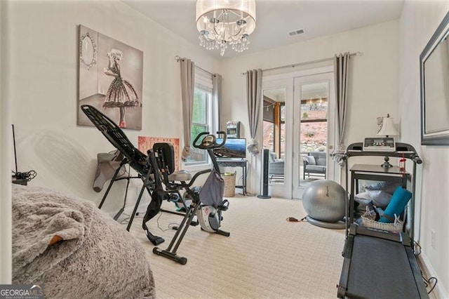 workout area with carpet flooring, visible vents, and a chandelier