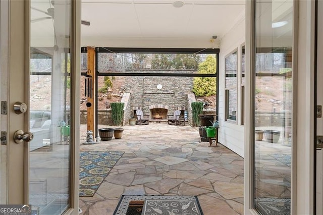 unfurnished sunroom with an outdoor stone fireplace