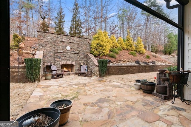 view of patio featuring an outdoor stone fireplace