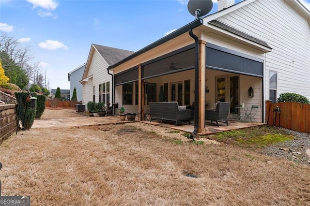 back of property with outdoor lounge area, a patio, fence, and a ceiling fan