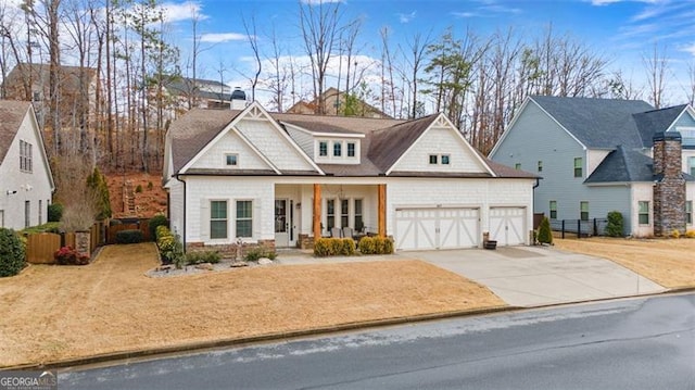 view of front of house featuring concrete driveway, an attached garage, fence, and a chimney