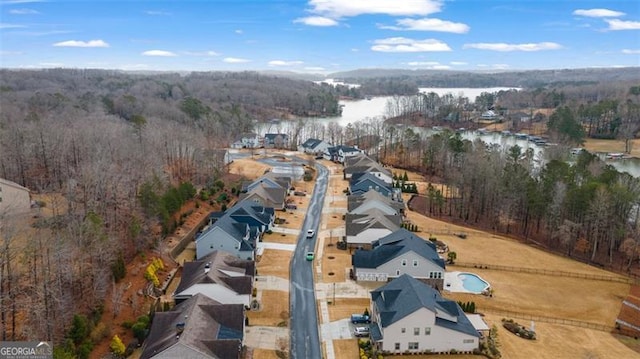 birds eye view of property featuring a view of trees and a water view