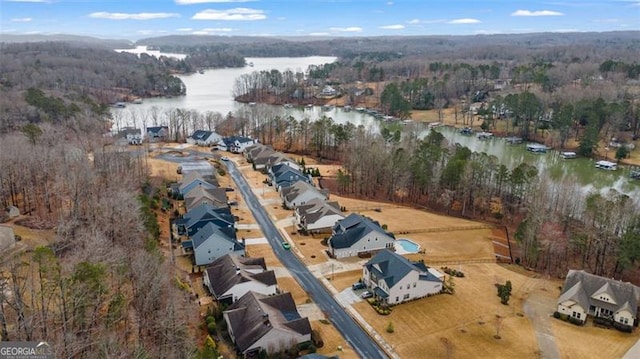 aerial view with a forest view and a water view