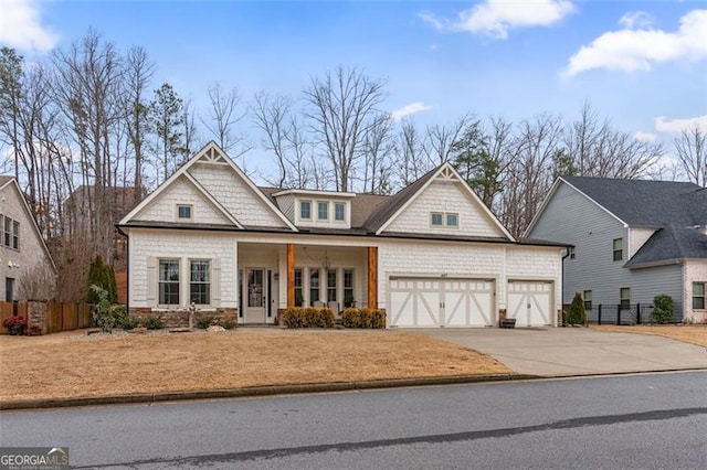 craftsman-style house featuring concrete driveway, covered porch, fence, and a garage